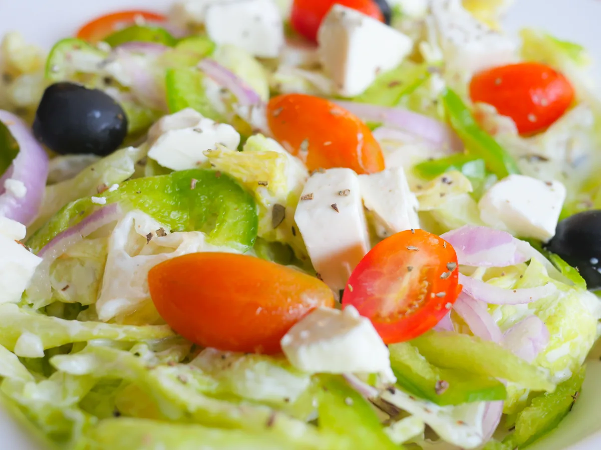A Greek salad of cherry tomatoes, white feta cubes, black olives, red onion and green pepper